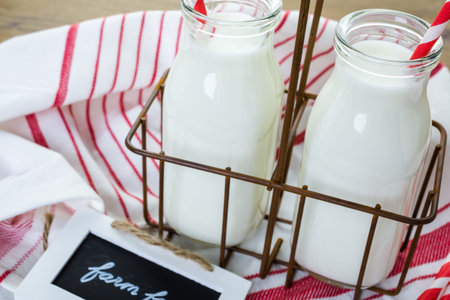 Fresh farm milk in glass jars on wood table