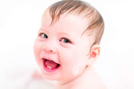 Cute baby girl taking a bath with bubbles.の写真素材