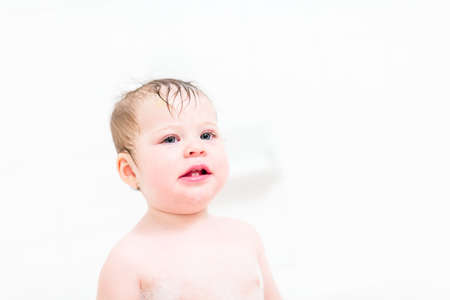 Cute baby girl taking a bath with bubbles.の写真素材