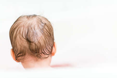 Cute baby girl taking a bath with bubbles.の写真素材