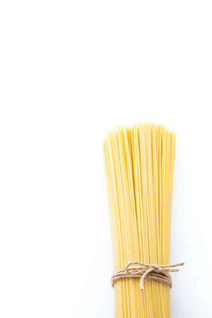 Organic yellow spaghetti pasta on a white background.の写真素材