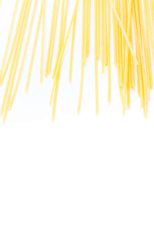 Organic yellow spaghetti pasta on a white background.の写真素材