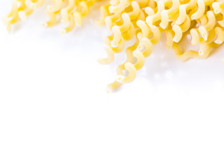 Organic yellow pasta on a white background.