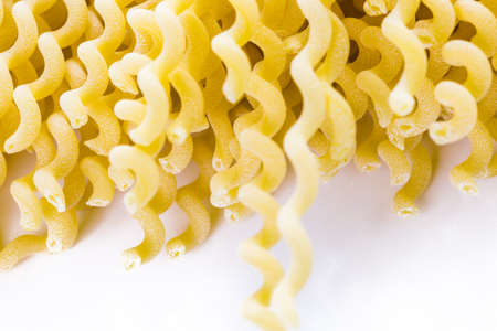 Organic yellow pasta on a white background.の写真素材