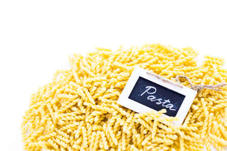 Organic yellow gemelli pasta on a white background.の写真素材