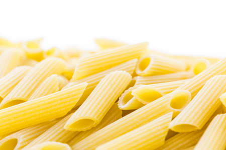 Organic yellow rigate pasta on a white background.の写真素材