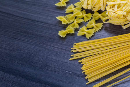 Variety og organic dry pasta on wood board.の写真素材