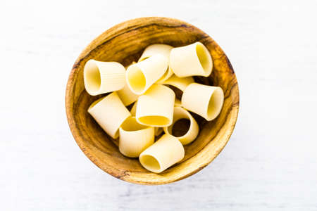 Organic dry pasta in small round bowl.の写真素材