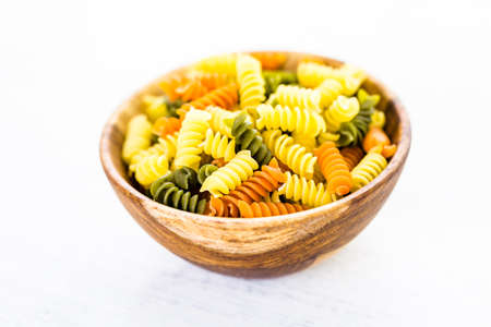 Organic dry pasta in small round bowl.の写真素材