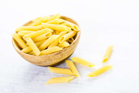 Organic dry pasta in small round bowl.の写真素材