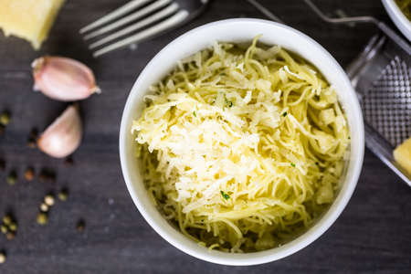 Cooking organic pasta with garlic herbs and parmesan cheese.の写真素材