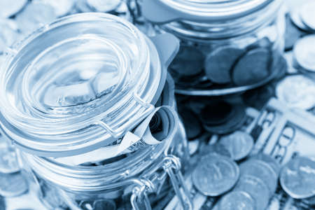 Saving money into glass jar for future investment.の写真素材