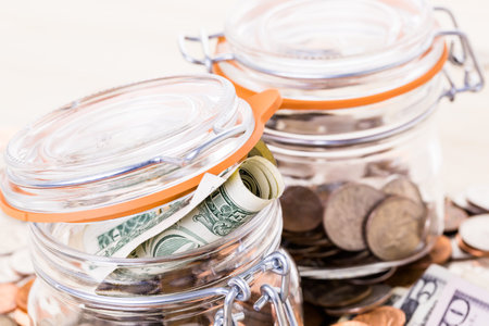 Saving money into glass jar for future investment.の写真素材