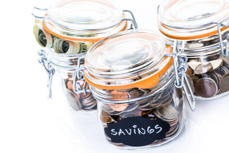 Saving money into glass jar for future investment.