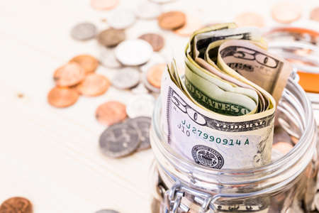 Saving money into glass jar for future investment.の写真素材