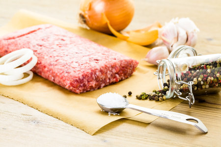 Ground pork on the table with other ingredients for recipe.