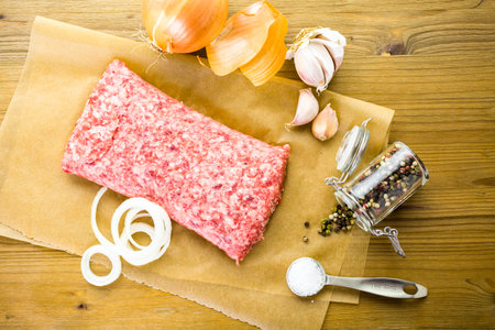 Ground pork on the table with other ingredients for recipe.