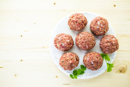 Cooking large homemade Italian meatballs for dinner.