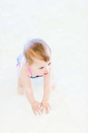 Cute baby girl swimming at indoor swimming pool.の写真素材