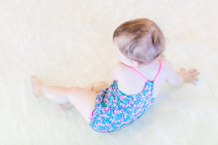 Cute baby girl swimming at indoor swimming pool.の写真素材