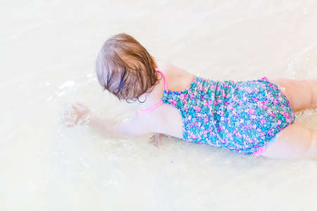 Cute baby girl swimming at indoor swimming pool.の写真素材