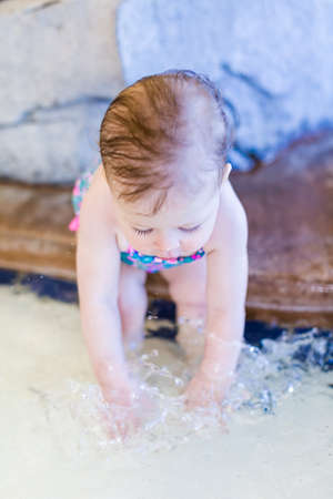 Cute baby girl swimming at indoor swimming pool.の写真素材