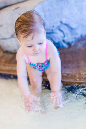 Cute baby girl swimming at indoor swimming pool.の写真素材