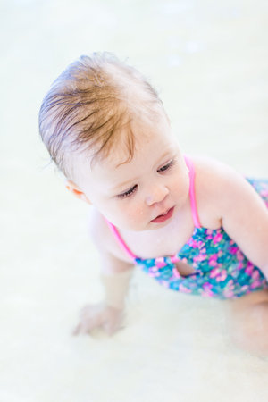 Cute baby girl swimming at indoor swimming pool.の写真素材
