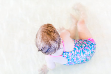 Cute baby girl swimming at indoor swimming pool.の写真素材