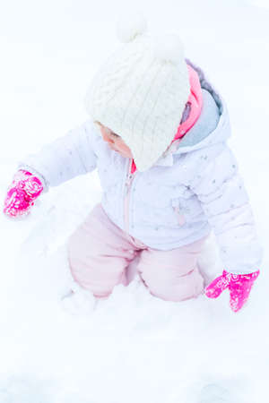 Cute toddler enjoying play in fresh snow.の写真素材