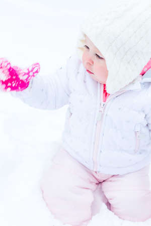 Cute toddler enjoying play in fresh snow.の写真素材