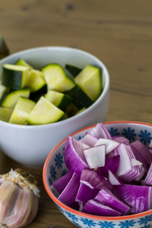Fresh ingredients for preparing roasted mixed vegetables on the table.の写真素材