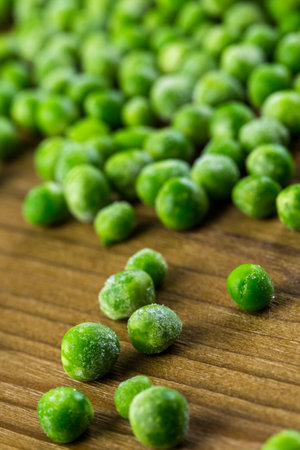 Organic frozen baby sweet peas on wood board.の写真素材
