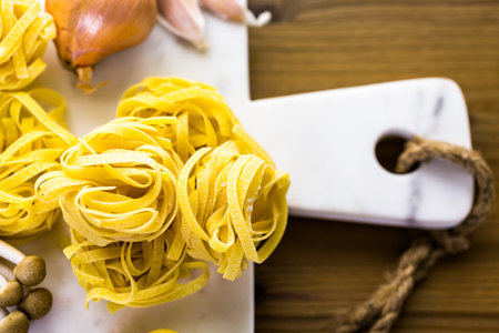 Ingredients for preparing fettuccine with creamy mushroom sauce.の写真素材