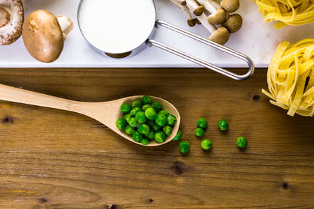 Ingredients for preparing fettuccine with creamy mushroom sauce.の写真素材