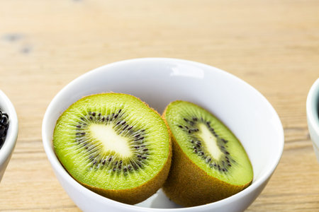 Organic fresh fruit in round bowls on wood table.の写真素材