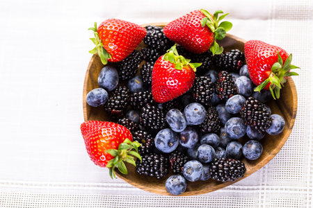 Organic fresh mixed fruit in wood bowl on the table.の写真素材