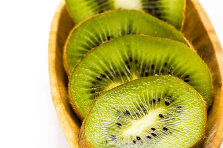 Organic fresh kiwi in wood bowl on a white .の写真素材