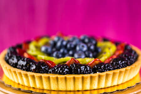 Fresh fruit tart on cake stand on wood table.の写真素材