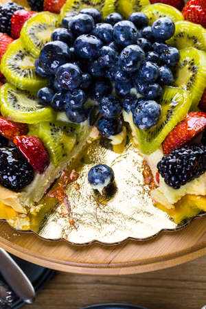 Fresh fruit tart on cake stand on wood table.の写真素材