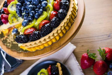 Fresh fruit tart on cake stand on wood table.の写真素材