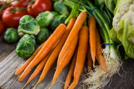 Fresh organic vegetable in season on old farm table.の写真素材