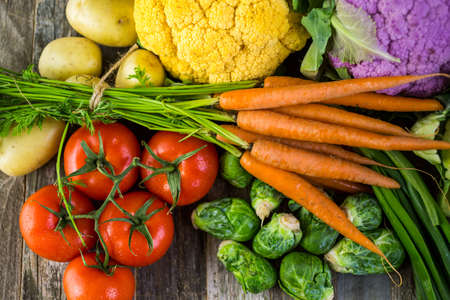 Fresh organic vegetable in season on old farm table.の写真素材