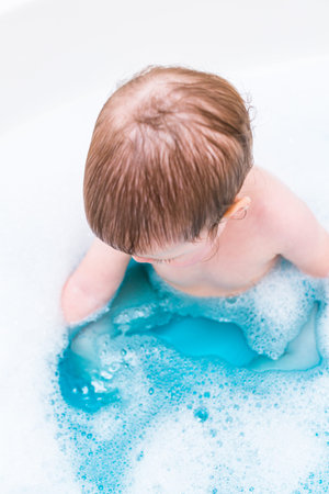 Baby girl having a good time during the bath time.の写真素材