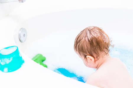 Baby girl having a good time during the bath time.の写真素材