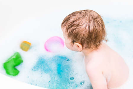 Baby girl having a good time during the bath time.の写真素材