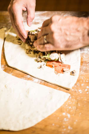 Preparing Pepperoni calzone in Italian restaurant.の写真素材