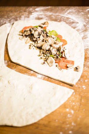 Preparing Pepperoni calzone in Italian restaurant.の写真素材