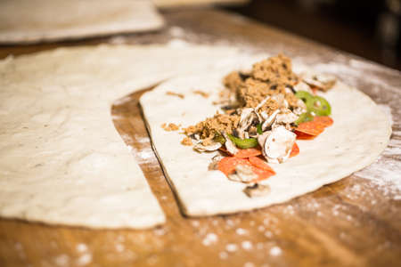 Preparing Pepperoni calzone in Italian restaurant.の写真素材
