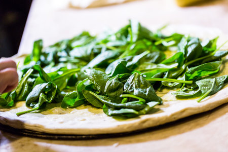 Preparing spinach pizza in Italian restaurant.の写真素材